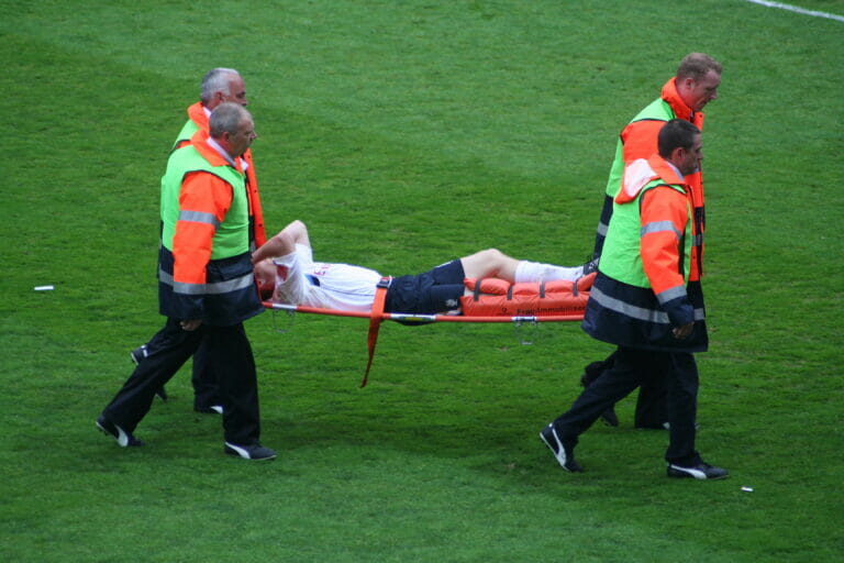 Professional footballer is carried off the field.